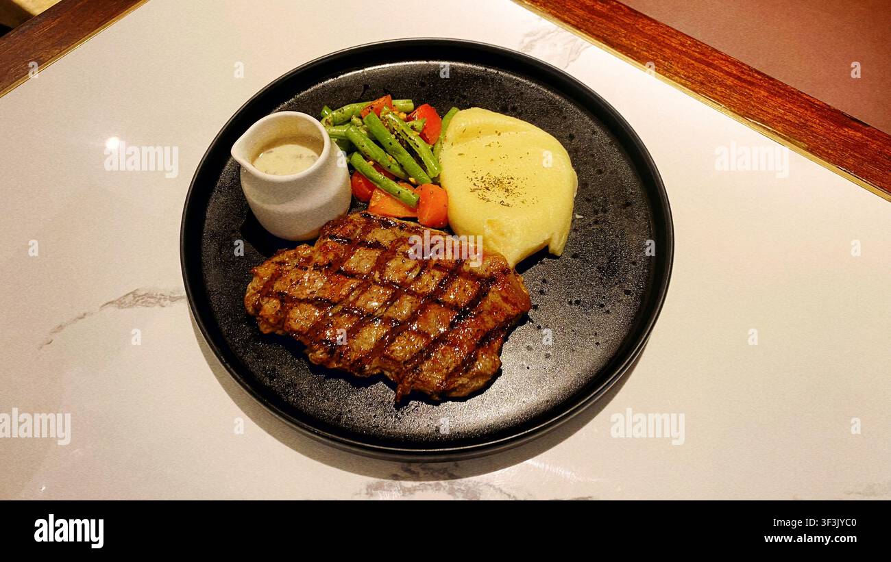 Saftiges toskanisches Steak, zubereitet mit aromatischen Kräutern und köstlicher Präsentation, das ein reichhaltiges und geschmackvolles Esserlebnis zeigt, inspiriert von der italienischen Küche Stockfoto