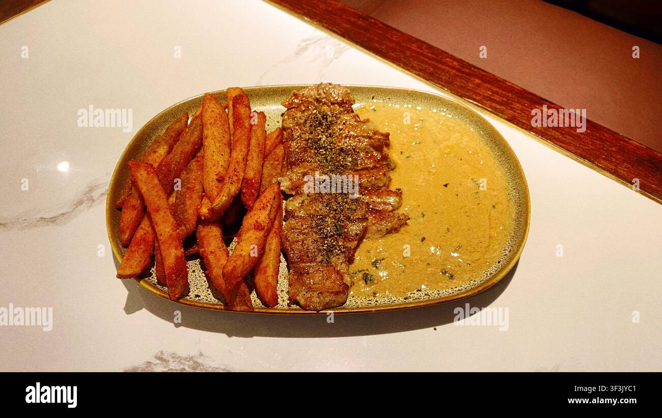 Saftiges toskanisches Steak, zubereitet mit aromatischen Kräutern und köstlicher Präsentation, das ein reichhaltiges und geschmackvolles Esserlebnis zeigt, inspiriert von der italienischen Küche - Smartphone-aufgenommenes Stockfoto