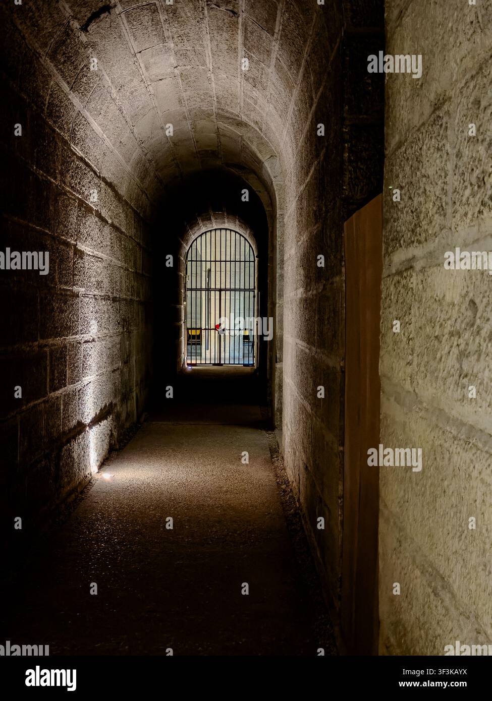 Ein enger Tunnel mit einem Metalltor am Ende im Musée de l'Armée im Hôtel National des Invalides in Paris, Frankreich Stockfoto