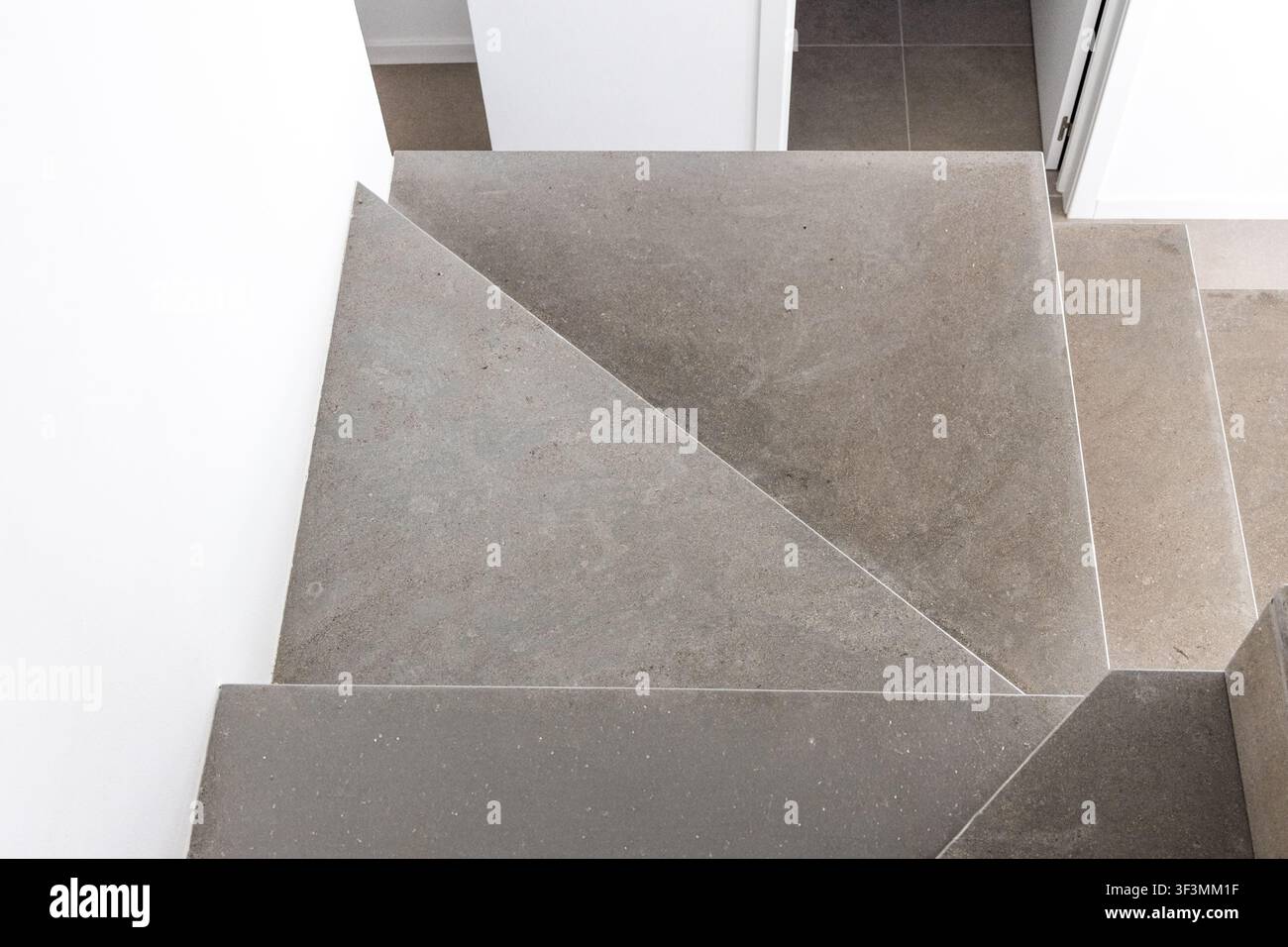 Eine Hochwinkelansicht einer zeitgenössischen Betontreppe mit klaren Linien und einer neutralen Farbpalette, die ein Gefühl moderner Architektur vermittelt Stockfoto