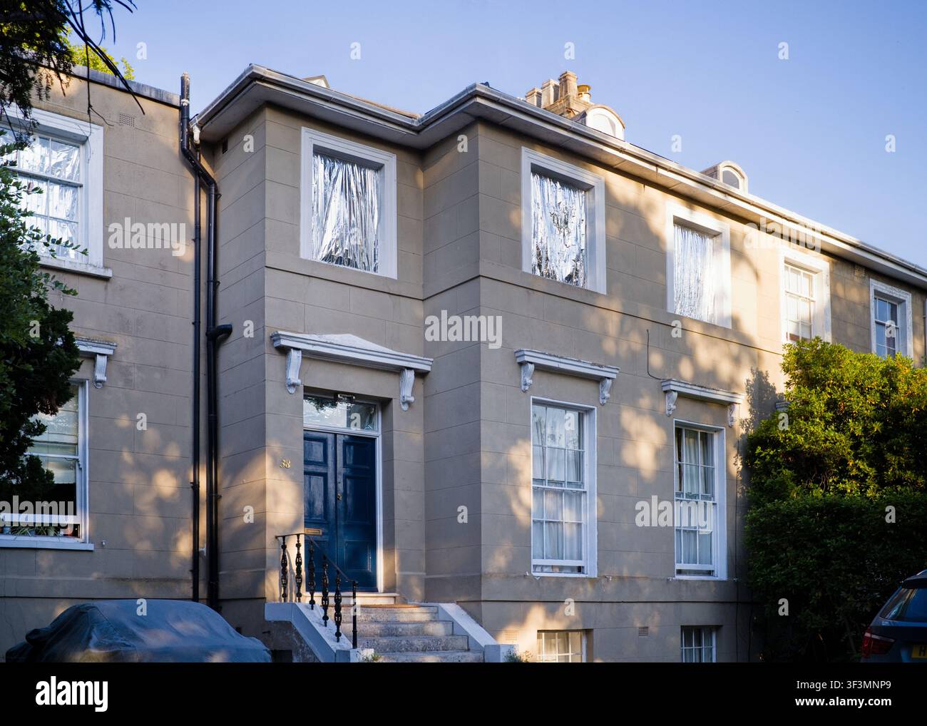 Großes Haus in Surbiton mit Folie an den Fenstern, um die Hitze zu stoppen Stockfoto