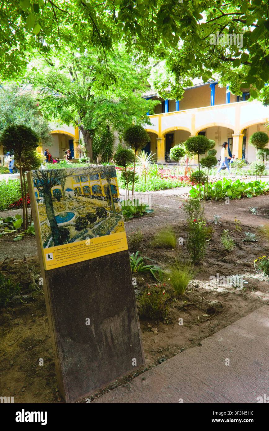 Eine Informationsplakette, die Van Goghs Gemälde zeigt, steht im Gartenhof des Espace Van Gogh in Arles, Frankreich. Stockfoto