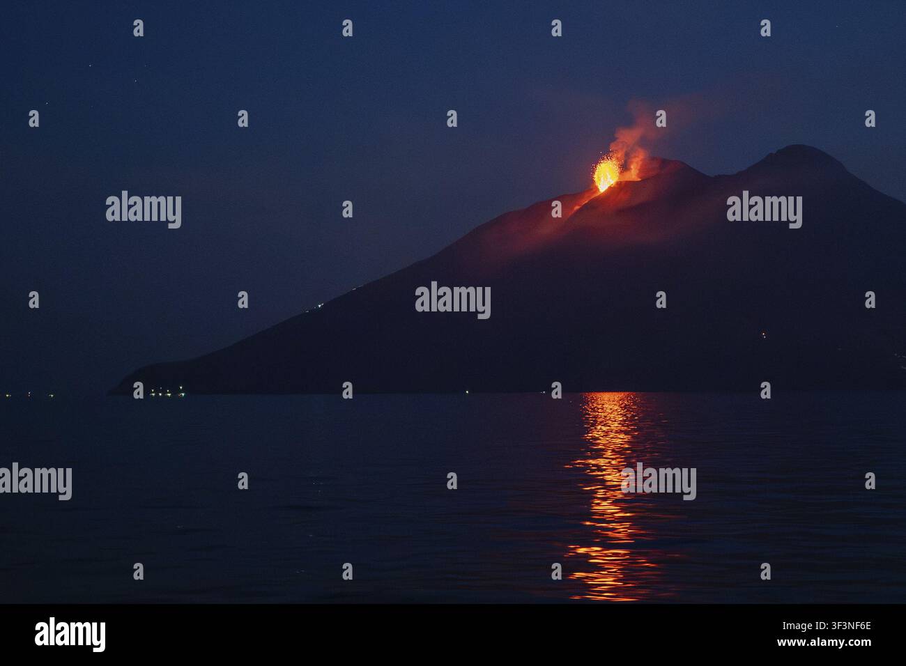 Vulkan mit Ausbruch und Lavafluss, der sich auf der Meeresoberfläche widerspiegelt, Stromboli-Vulkan, Mittelmeer-Leuchtturm, Äolische Inseln, Tyrrhenisches Meer Stockfoto