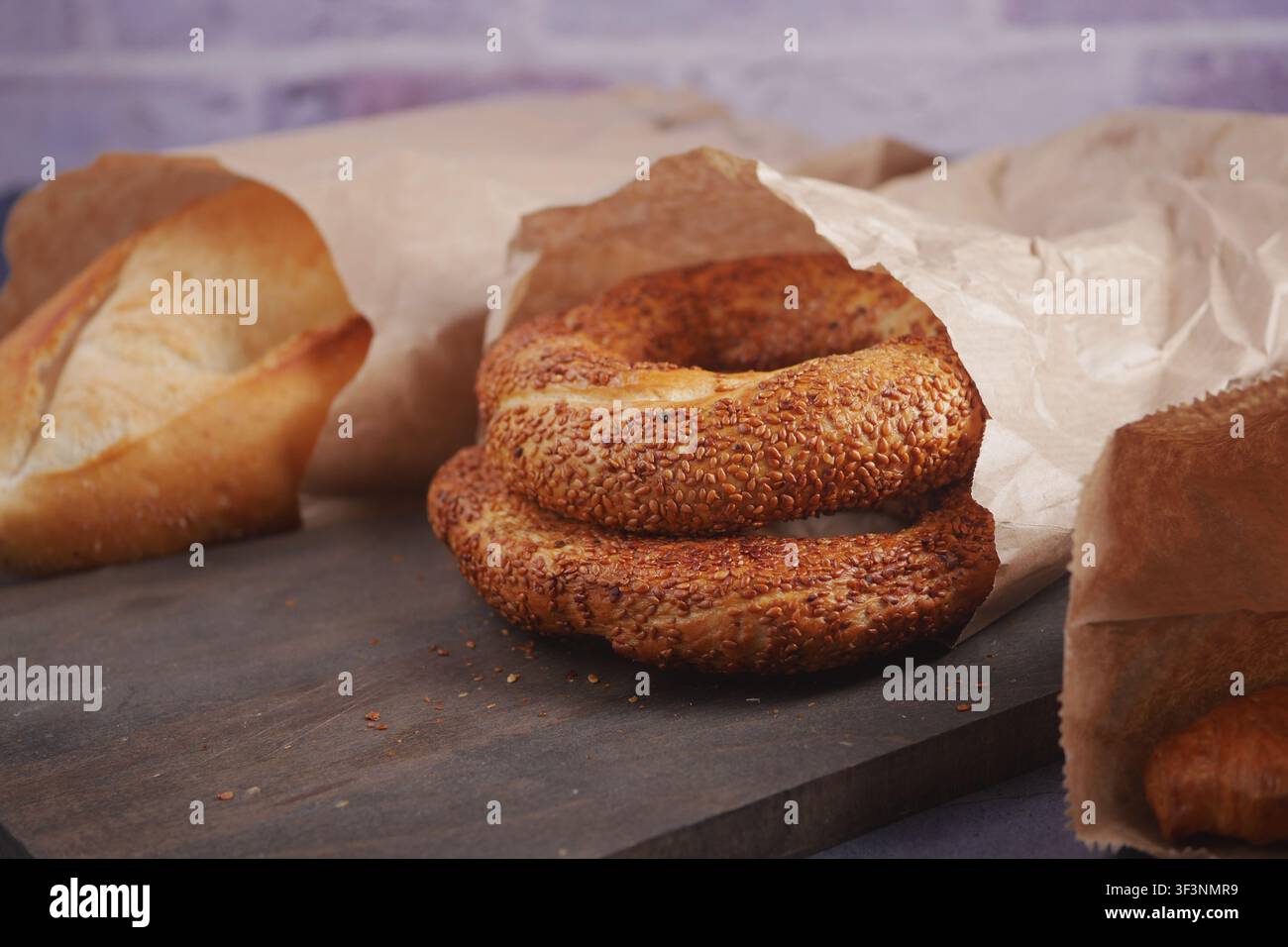 Frisches Brot und Sesambaguettes auf Holzbrett Stockfoto