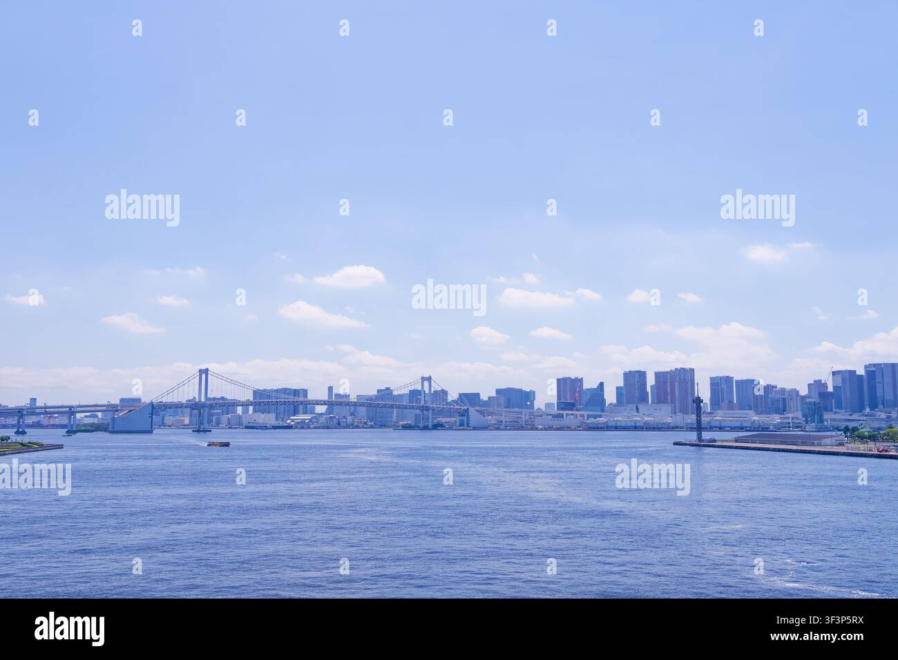 Weite panoramische Skyline von Tokyo Bay mit der Rainbow Bridge und dem zeitgenössischen Uferviertel an einem hellen Sommernachmittag in Tokio, Japan Stockfoto