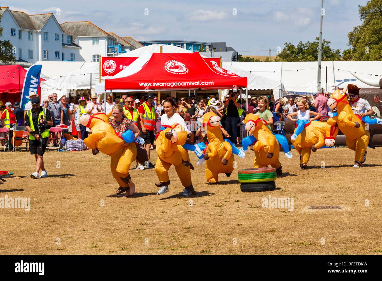 Swanage, Dorset UK. 25. Juli 2026. Das Swanage-Karneval beginnt mit dem Thema „Ein verrückter Western im Carnival Canyon“ mit Aktivitäten und Veranstaltungen in der ganzen kommenden Woche. Tausende strömen an einem heißen sonnigen Tag nach Swanage zum Karneval. Zu den heutigen Veranstaltungen gehört der Rodeo Stampede. Teilnehmer nehmen am Rodeo Stampede teil. Credit: Carolyn Jenkins/Alamy Live News Stockfoto