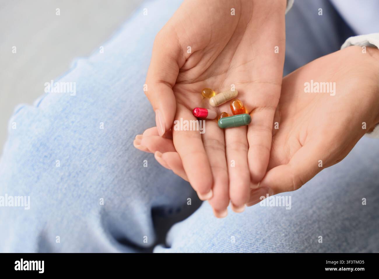 Frauenhände halten verschiedene bunte Kapseln und Pillen, Gesundheits- und Wellnesskonzept, Medikation und Einnahme von Nahrungsergänzungsmitteln Stockfoto
