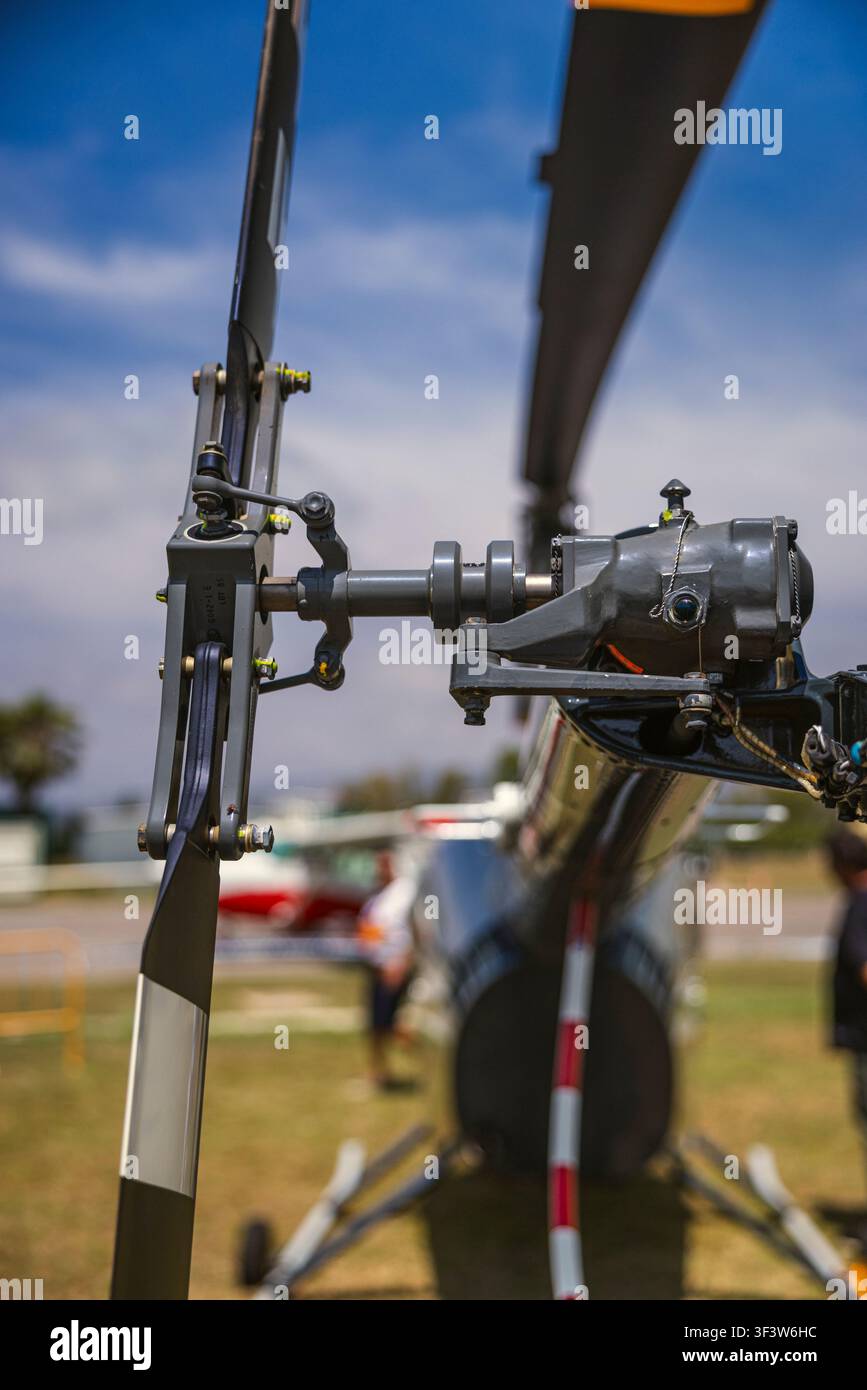 Eine detaillierte Ansicht eines Hubschrauberrotors vor einem klaren blauen Himmel, die die komplexe Mechanik und Ingenieurskunst der modernen Luftfahrttechnologie hervorhebt Stockfoto