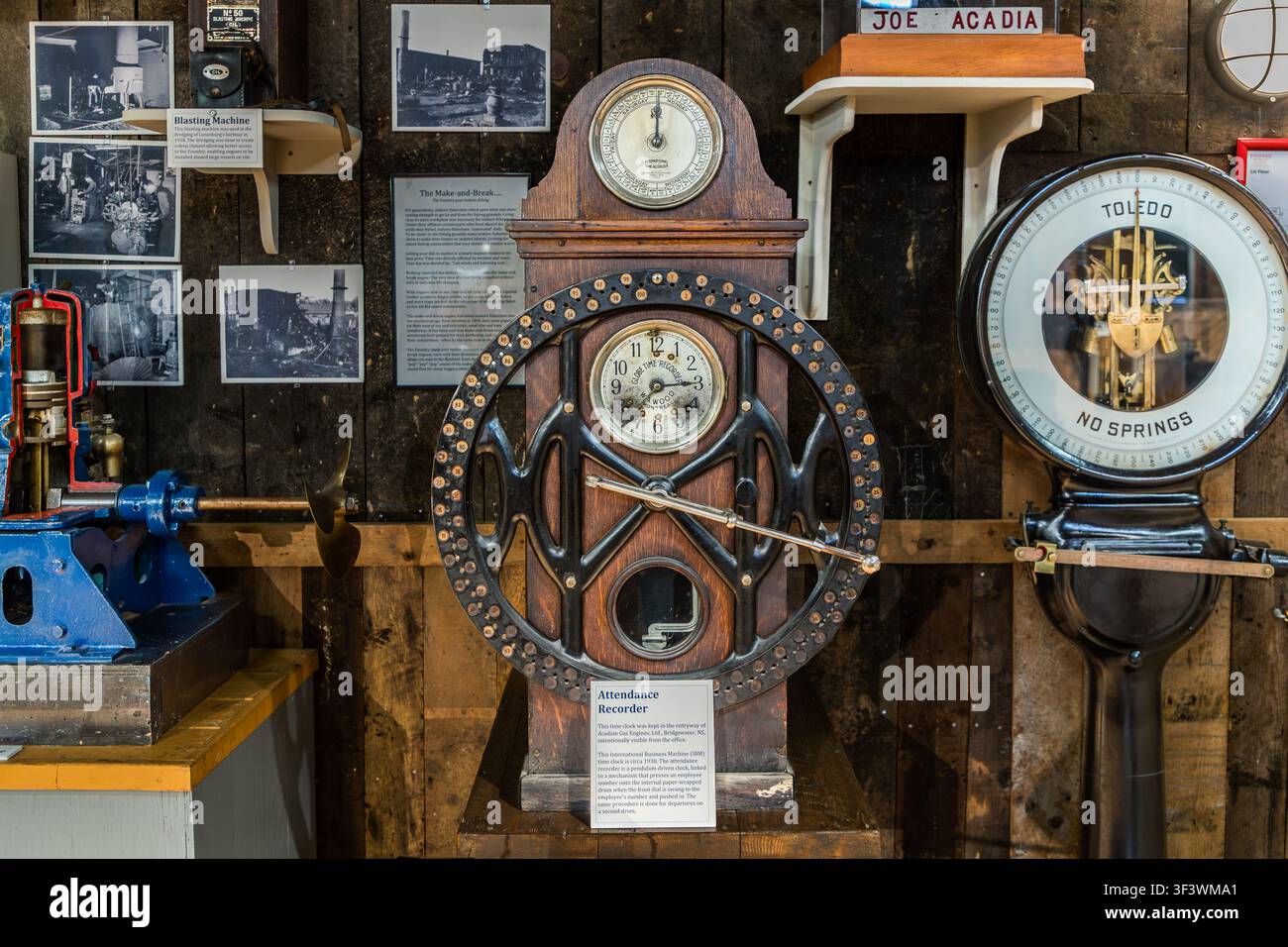 Eine mechanische Stechuhr und eine Toledo-Waage aus einer Fischfabrik sind im Fischereimuseum des Atlantiks in der Altstadt von Lunenburg, Nova Scotia, ausgestellt. Die Stechuhr, beschriftet mit „Attendance Recorder“, wurde verwendet, um die Arbeitsstunden von Fabrikarbeitern im industriellen Fischverarbeitungssektor zu erfassen. Lunenburg, Nova Scotia, Kanada Stockfoto