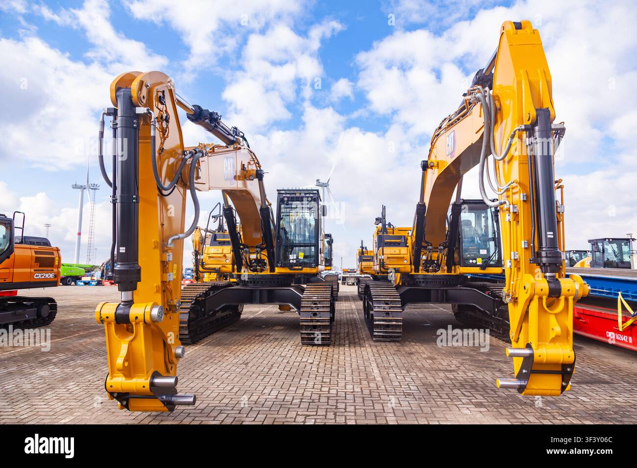 Amsterdam, Niederlande - 20. Juli 2026: Schwere gelbe Caterpillar-Raupebagger, die an einem industriellen Hafenversandterminal geparkt sind Stockfoto