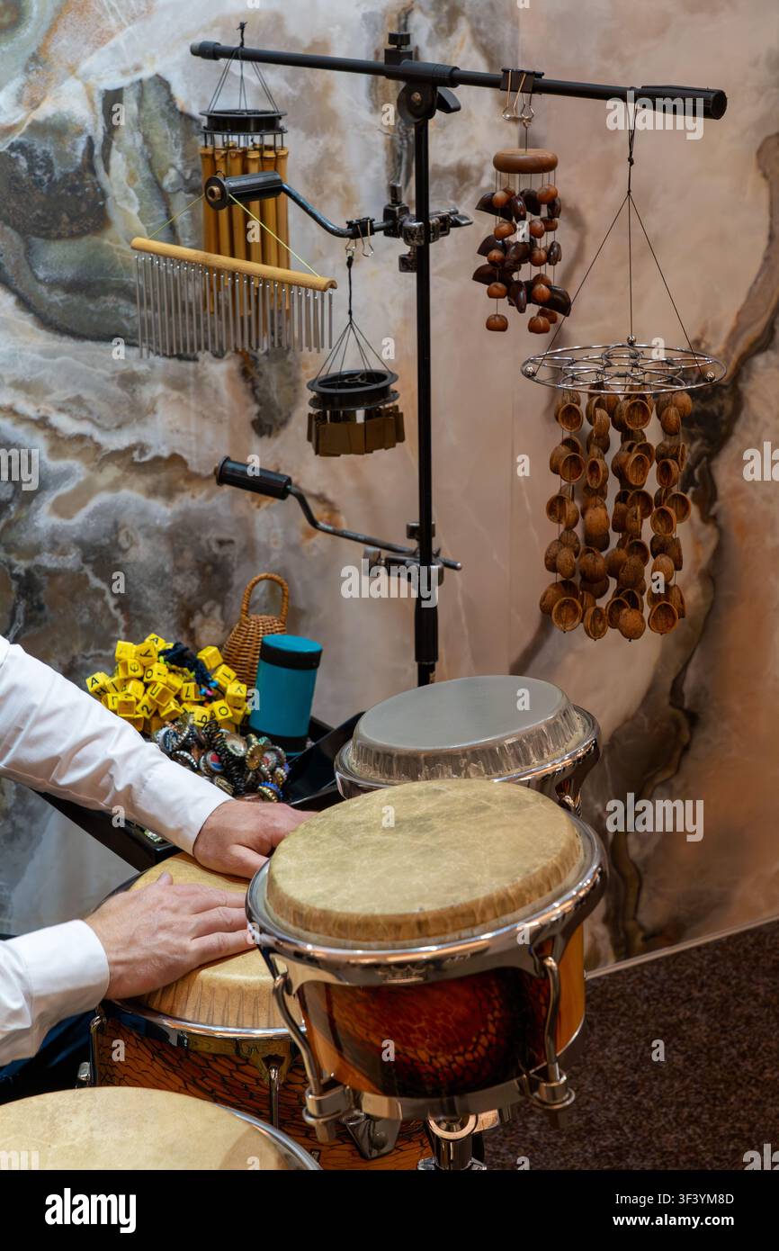 Verschiedene Weltmusik-Schlaginstrumente mit einem Musiker, der Handtrommeln spielt, und natürlichen akustischen Soundeffekt-Instrumenten für Rhythmusaufführungen Stockfoto