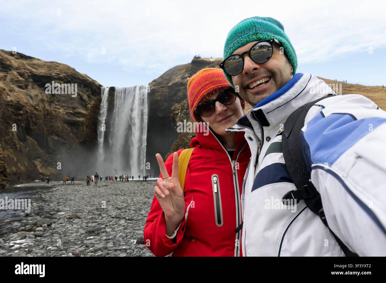 Lächelndes Paar, Mann und Frau machen Selfie vor dem Hintergrund des Skogafoss-Wasserfalls, Island. Stockfoto