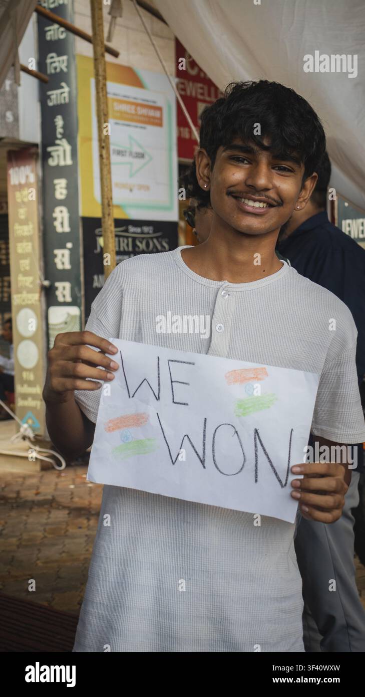 Handgeschriebenes „Wir haben gewonnen“-Schild, das von einem Studenten bei der Siegeskundgebung in Bhopal gehalten wird Stockfoto