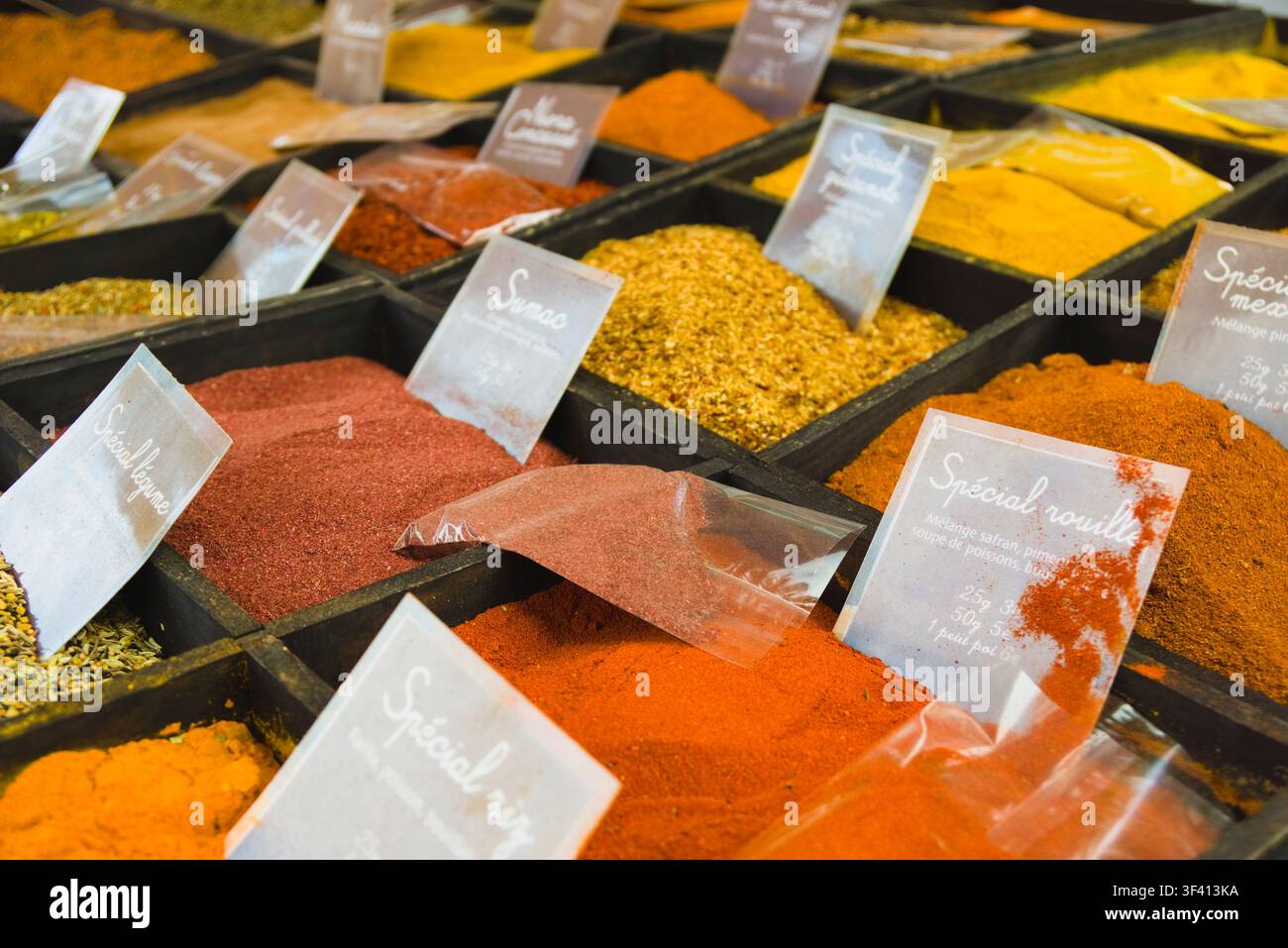 Verschiedene farbenfrohe Gewürze und Gewürzmischungen, die in Holzschalen auf einem Markt in Arles, Frankreich, ausgestellt sind. Stockfoto