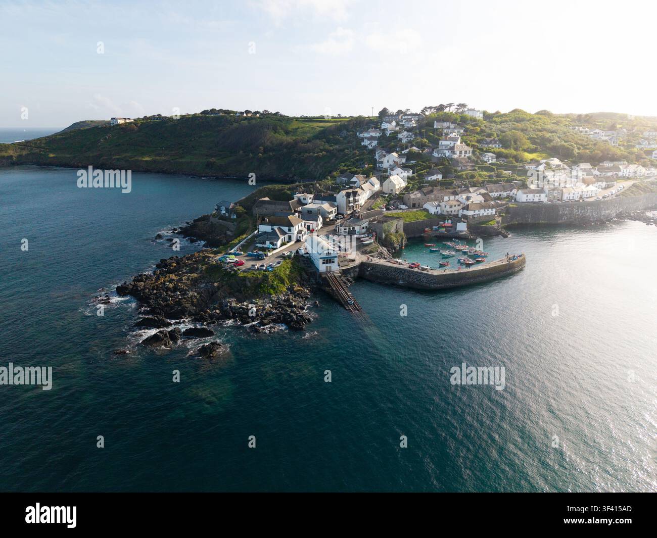 Luftbildlandschaft des Dorfes und des Hafens von Coverack in Cornwall, UK, das ein beliebtes Sommerurlaubsziel für Urlauber bei Sonnenaufgang ist Stockfoto