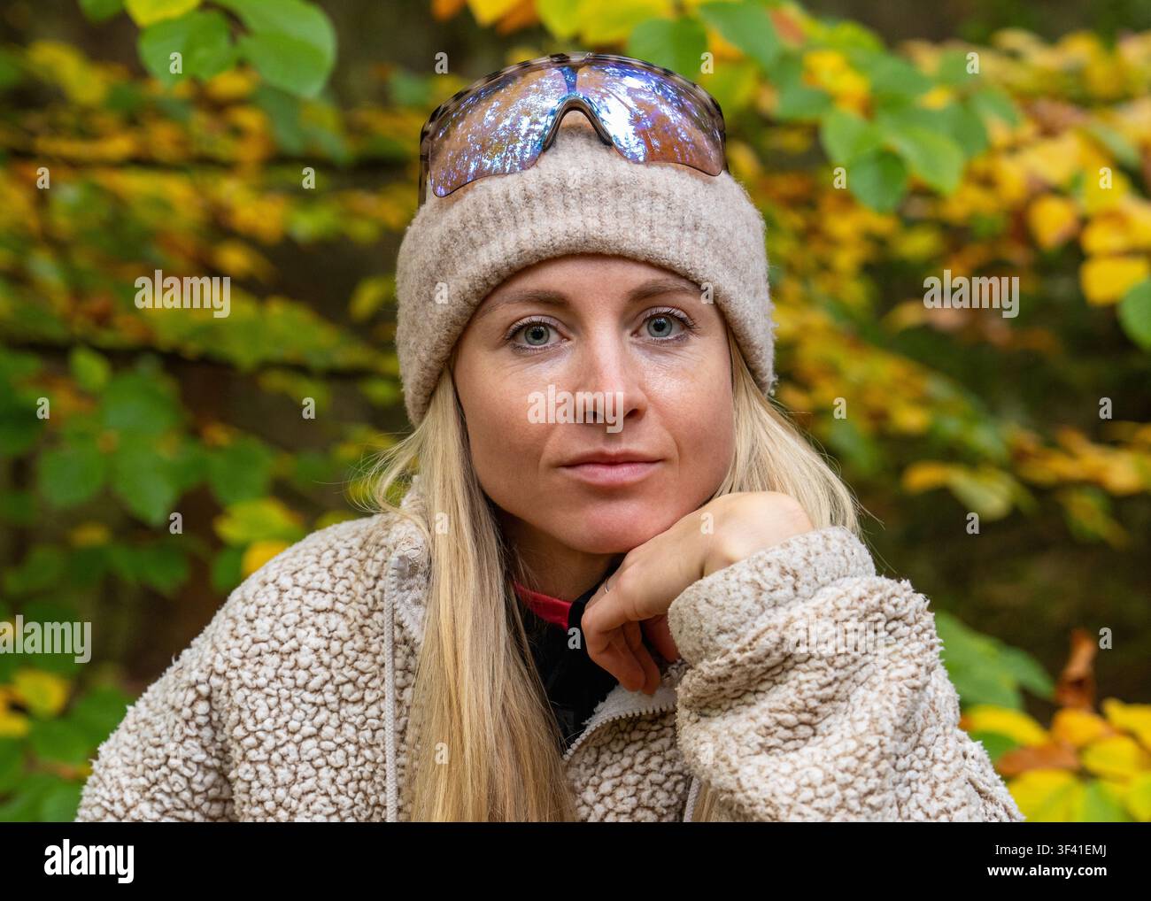 Porträt einer jungen Frau mit gestrickter Mütze, warmem Pullover in einem Herbstwald. Saisonale Mode, Outdoor-Lebensstil, Natur, Entspannung. Stockfoto