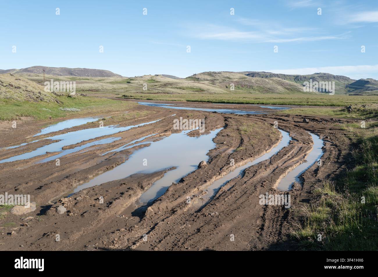 Tiefe 4x4-Reifenfurchen, die mit stehendem Wasser gefüllt sind, zeigen Landschaftsschäden, die durch Off-Road-Fahren in Island verursacht wurden. Stockfoto