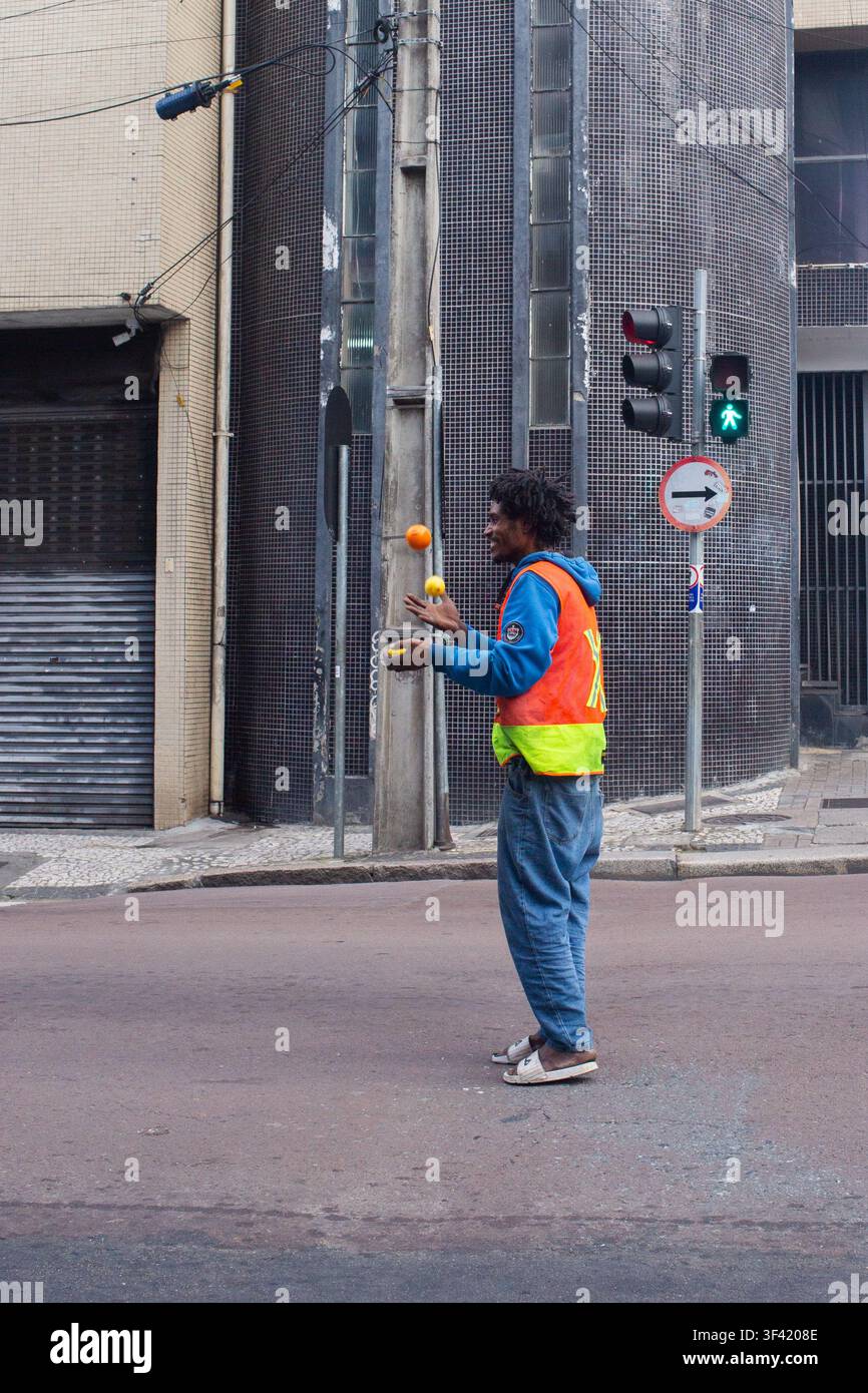 Vollständige Profilansicht des Straßenkünstlers, der bunte Bälle auf dem Zebrastreifen jongliert Stockfoto