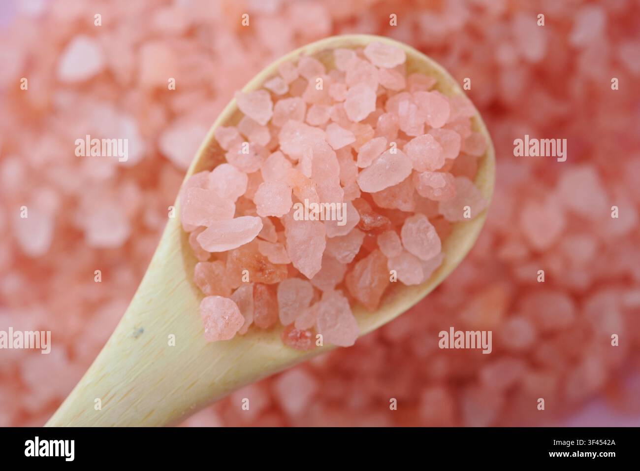 Rosa Salz in einem Holzlöffel auf einem Haufen rosa Salz Stockfoto