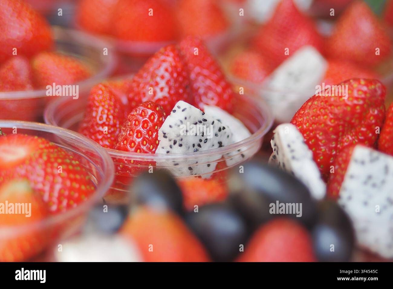 Frische Obstschalen mit Erdbeeren und Drachenfrucht-Scheiben Stockfoto