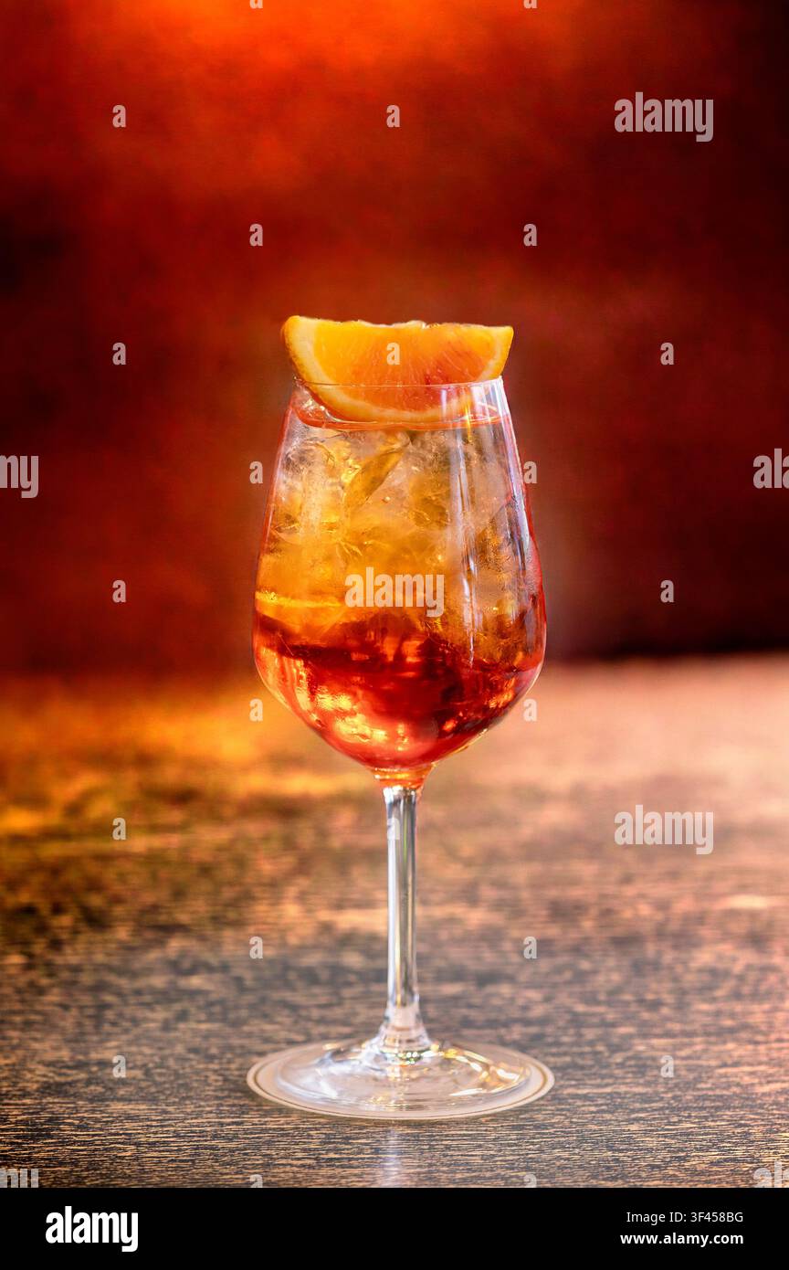 Fizzy Aperol Spritz Cocktail mit Eis und einer Orangenscheibe auf einem Bartisch Stockfoto