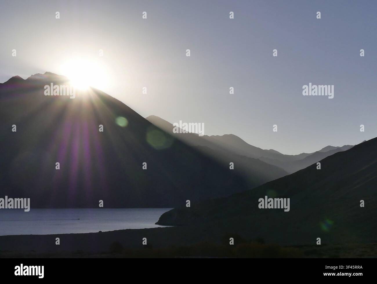 Sonnenaufgang mit Sonnenstrahl und Sonnenstern im Himalaya, über dem Berggipfel in Pangong Tso, Ladakh. Stockfoto
