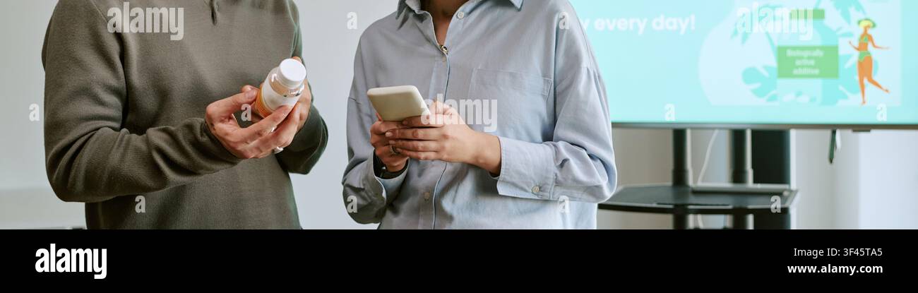 Kopfzeile von Mann und Frau, die ein Nahrungsergänzungsmittel-Produkt-Training überprüfen Stockfoto