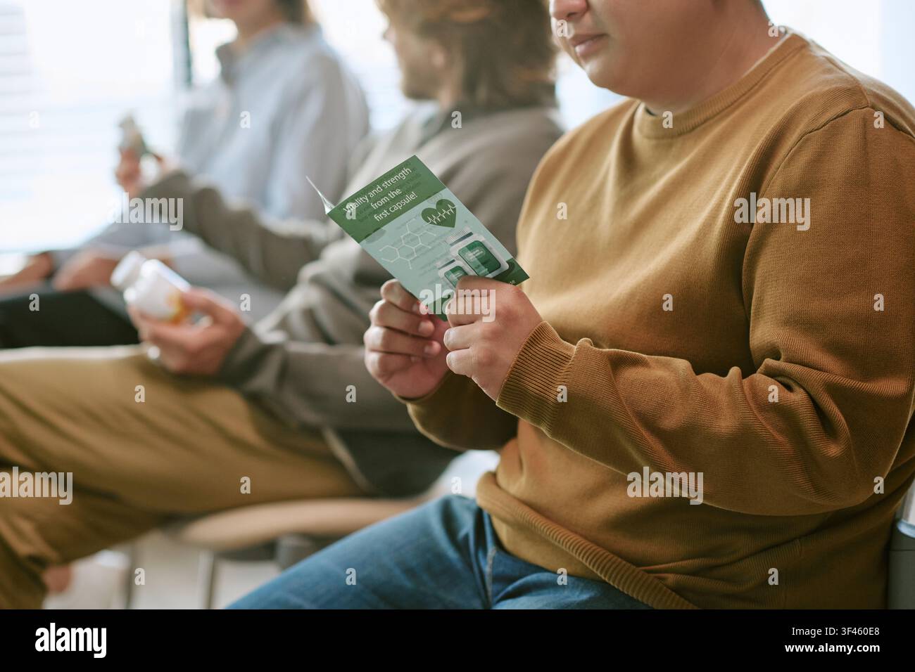 Junger erwachsener Mann, der eine Informationsbroschüre während einer Berufsausbildung durchsieht Stockfoto