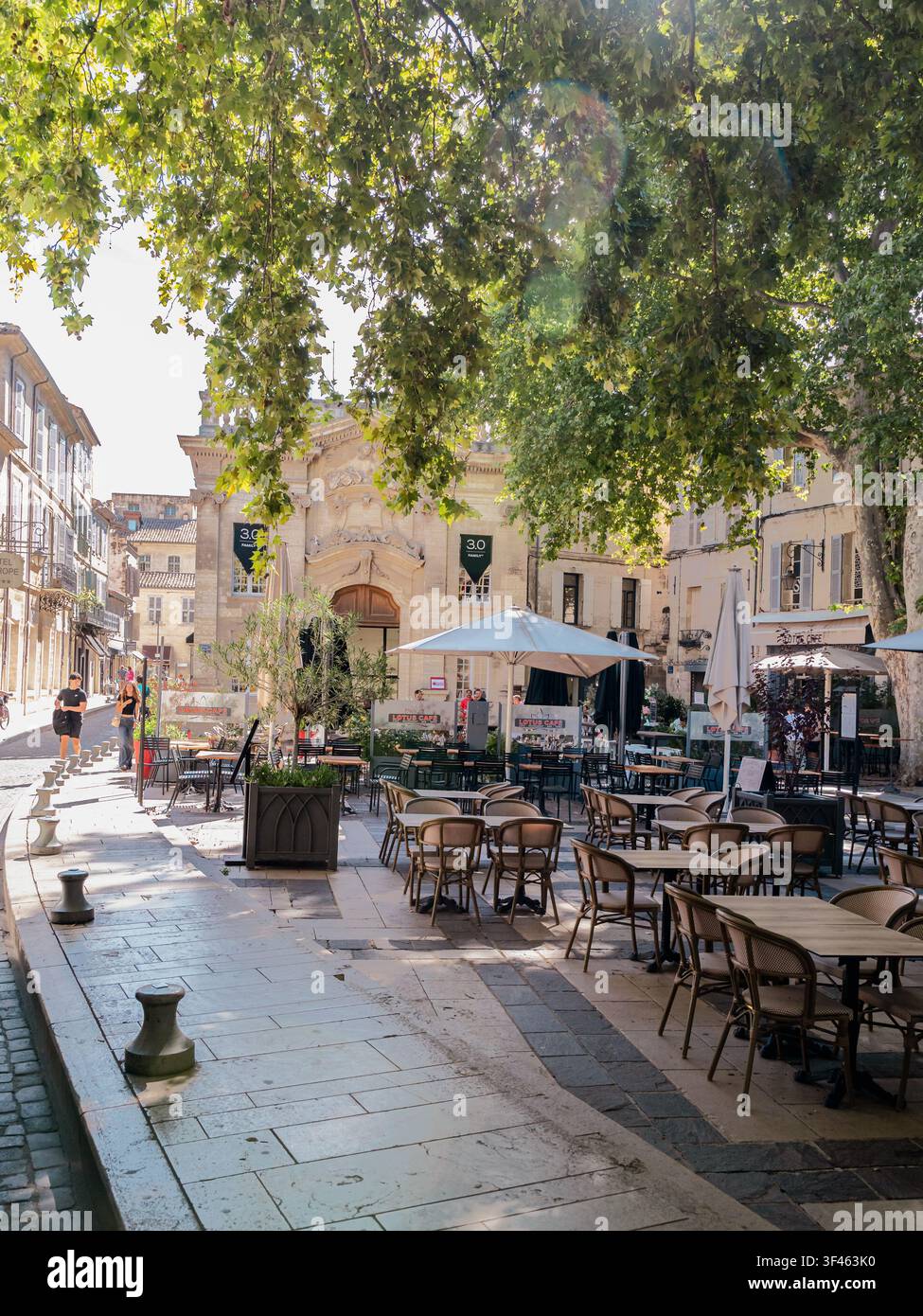 Sonniger Cafésplatz umgeben von historischen Gebäuden in der Altstadt von Avignon, Frankreich Stockfoto