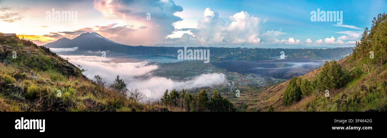 Atemberaubende panoramische Sonnenaufgangslandschaft vom Berg Batur in Kintamani, Bali, mit dem Batursee, schwarzen Lavafeldern, dem Kalderatale, den Trunyan-Hügeln und Stockfoto