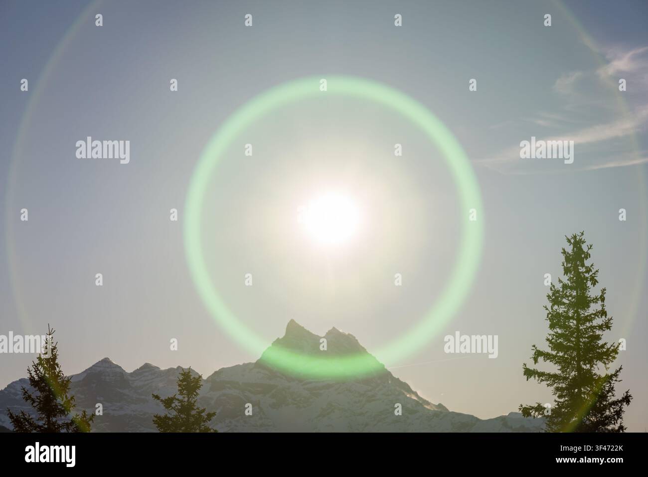 Wintersonne erzeugt starke Linsenreflexe über den Bergen Stockfoto