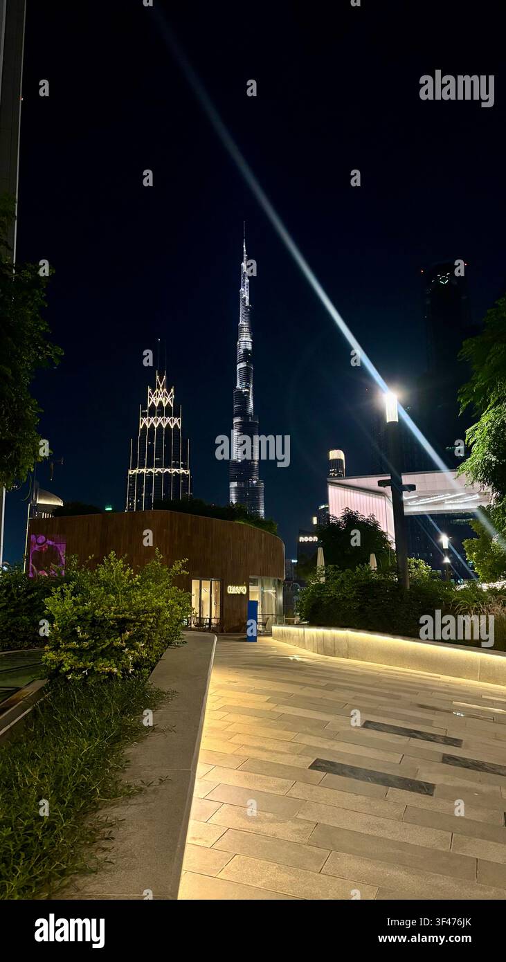 Burj Khalifa bei Nacht beleuchtet, gesehen von einem modernen Fußgängersteg in Downtown Dubai, Vereinigte Arabische Emirate. - Smartphone-aufgenommenes Stockfoto