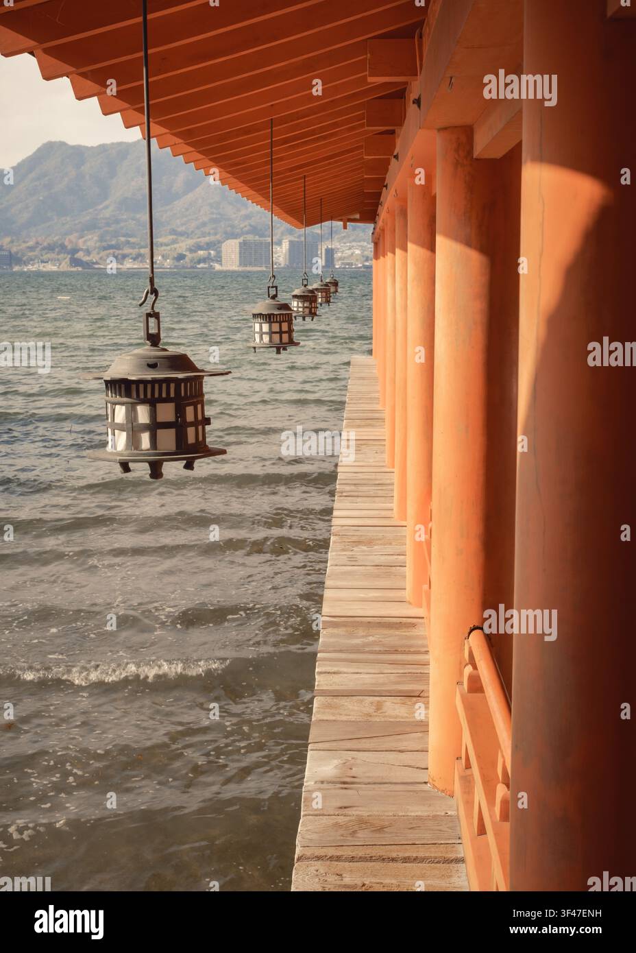 Lineare Perspektive, die auf das schwimmende Stelzenplattformdeck des Itsukushima-Schreins hinabschaut, mit einer hängenden Metalllaterne, Hiroshima, Japan. Stockfoto