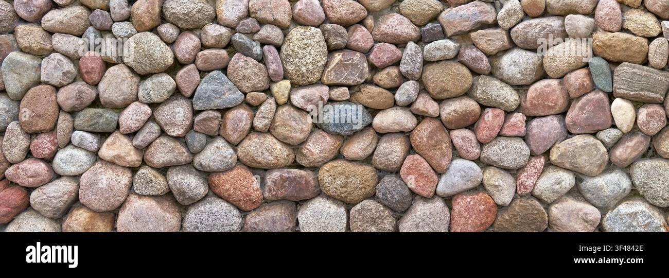 Breite Wand aus großen, verschiedenfarbigen Kieselsteinen Stockfoto