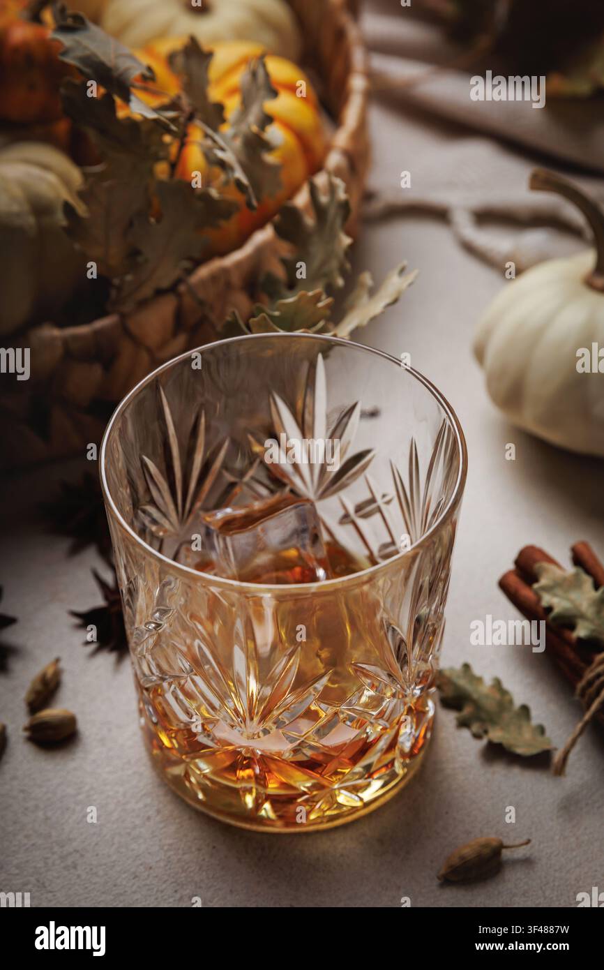 Bourbon mit Eis und Zimt auf einem gemütlichen Thanksgiving-Tisch.. Stockfoto