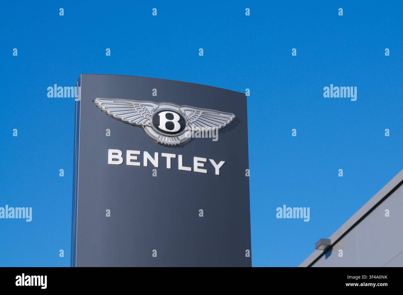 Grancia, Ticino, Schweiz – 15. Juni 2026: Niedrigwinkel-Außenaufnahme des offiziellen Totemschilds von Bentley Motors vor dem Autohaus in Grancia, Lugano. Stockfoto