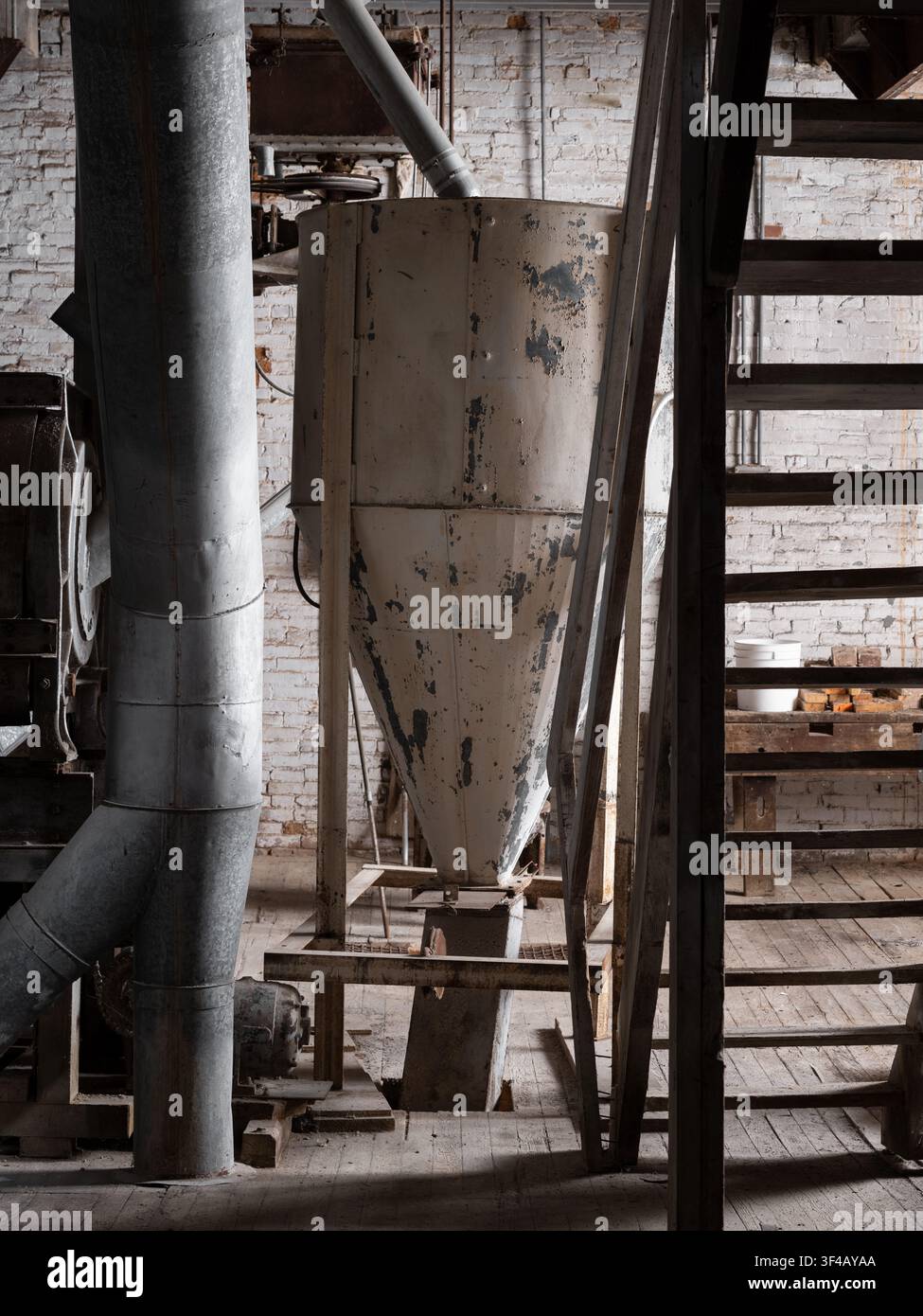 Millstadt Mühle, Millstadt, Illinois, USA. Ein bemalter Sammlerkegel neben der Treppe, mit abgeblättertem Anstrich und Ziegelmauerwerk. Stockfoto