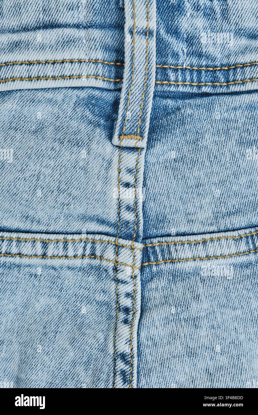 Textur hellblaue gewaschene Denimjeans zeigen Nähdetails und vertikale Gürtelschlaufe Stockfoto