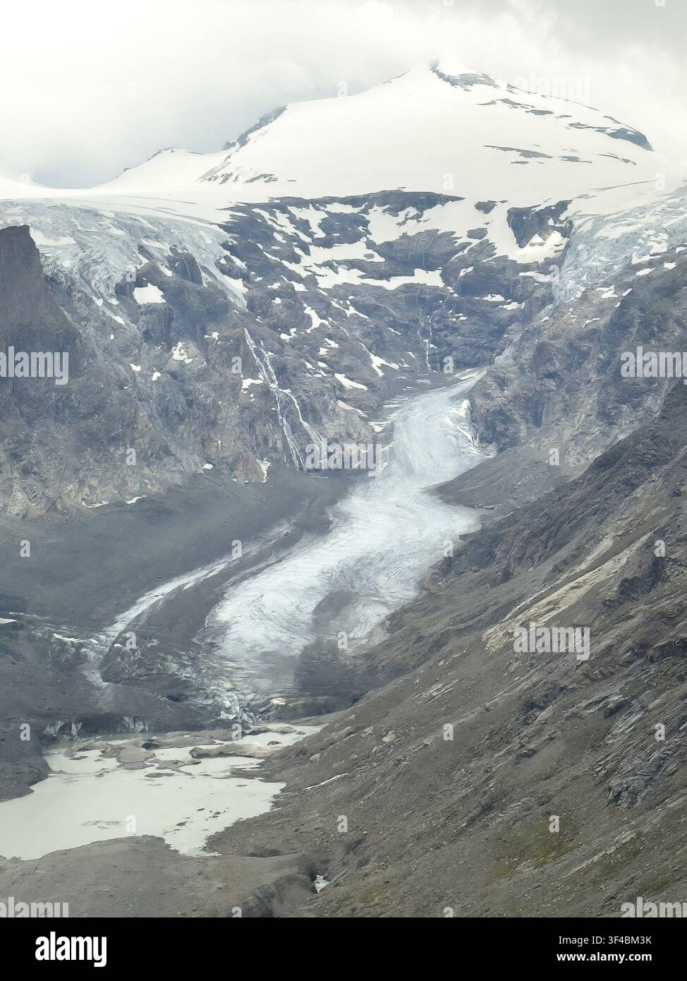 Blick von der Franz-Josefs-Höhe auf den Pasterze-Gletscher, der in der Mitte aufgrund von Klimawandel und globaler Erwärmung schmilzt, Teil des Gletschersees in der unteren linken Ecke Stockfoto
