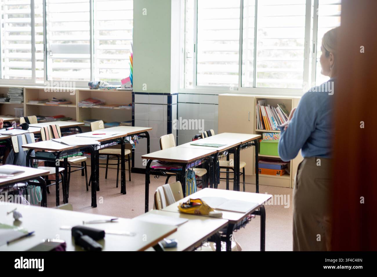 Lehrer steht in einem leeren Grundschulklassenzimmer, bevor die Schüler eintreffen. Stockfoto