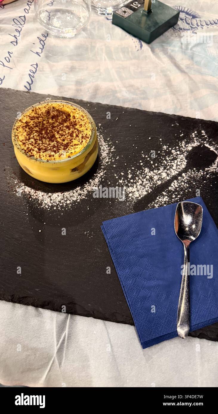 Klassisches italienisches Tiramisu-Dessert. Köstliches süßes italienisches Tiramisu serviert. Hausgemachte italienische Küche. Kalabrien, Italien. Der Teller mit Tiramisu. - Smartphone-aufgenommenes Stockfoto