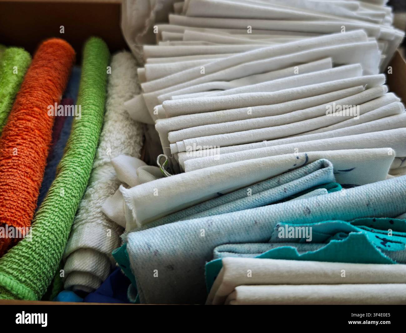 Eine Sammlung von Reinigungstüchern ist ordentlich in einer Schublade angeordnet, bereit für den Einsatz bei Hauswartungs- und Reparaturarbeiten. Stockfoto