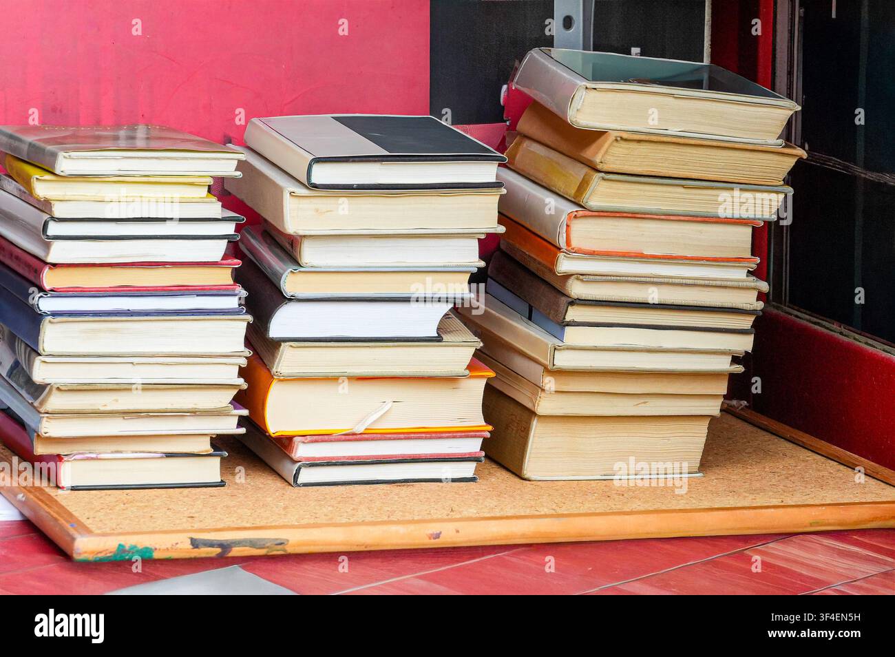 Stapel alter Bücher auf einem Tisch vor der Bibliothek Stockfoto