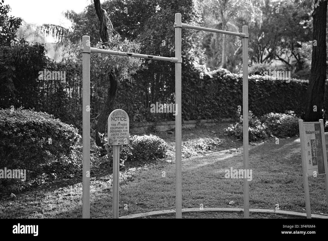 Outdoor-Fitness-Pull-Up-Bars und Übungsstation in einem öffentlichen Park, umgeben von Grünflächen in Corona, Kalifornien. Stockfoto