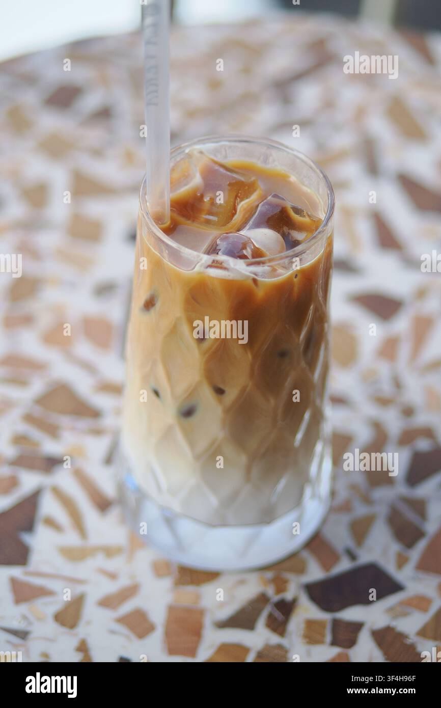 Eiskaffee-Getränk, das in einem hohen Glas auf einem Tisch serviert wird Stockfoto