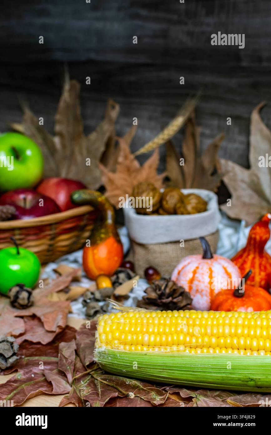 Herbststilleben mit verschiedenen geernteten Früchten und Kürbissen sowie getrockneten Blättern Stockfoto