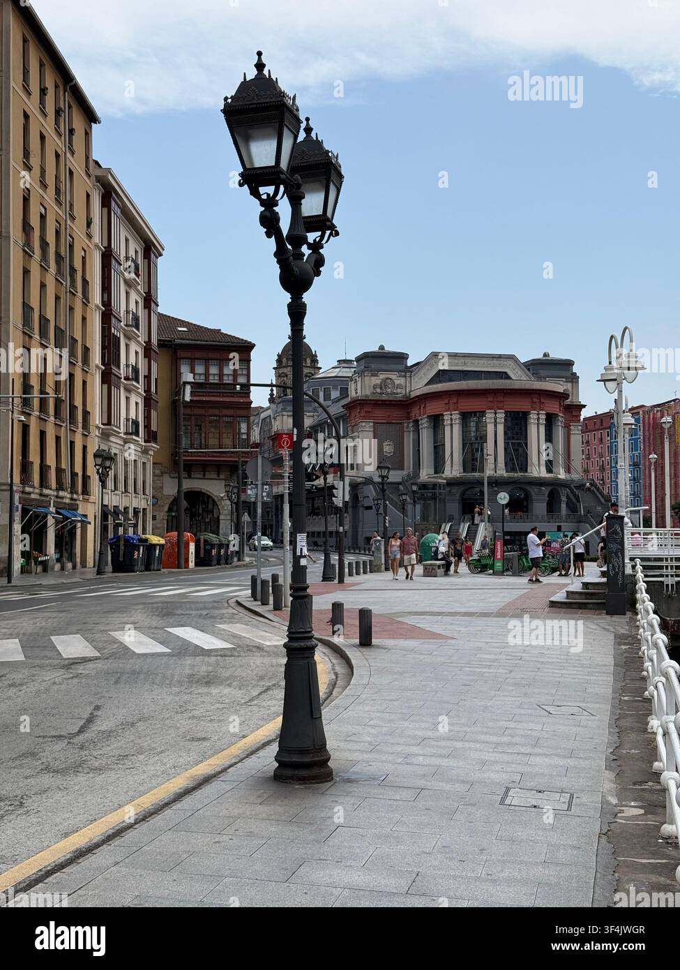 Mercado de la Ribera und traditionelle Straßenlaternen neben dem Nervion-Fluss in Bilbao, Spanien. - Smartphone-aufgenommenes Stockfoto