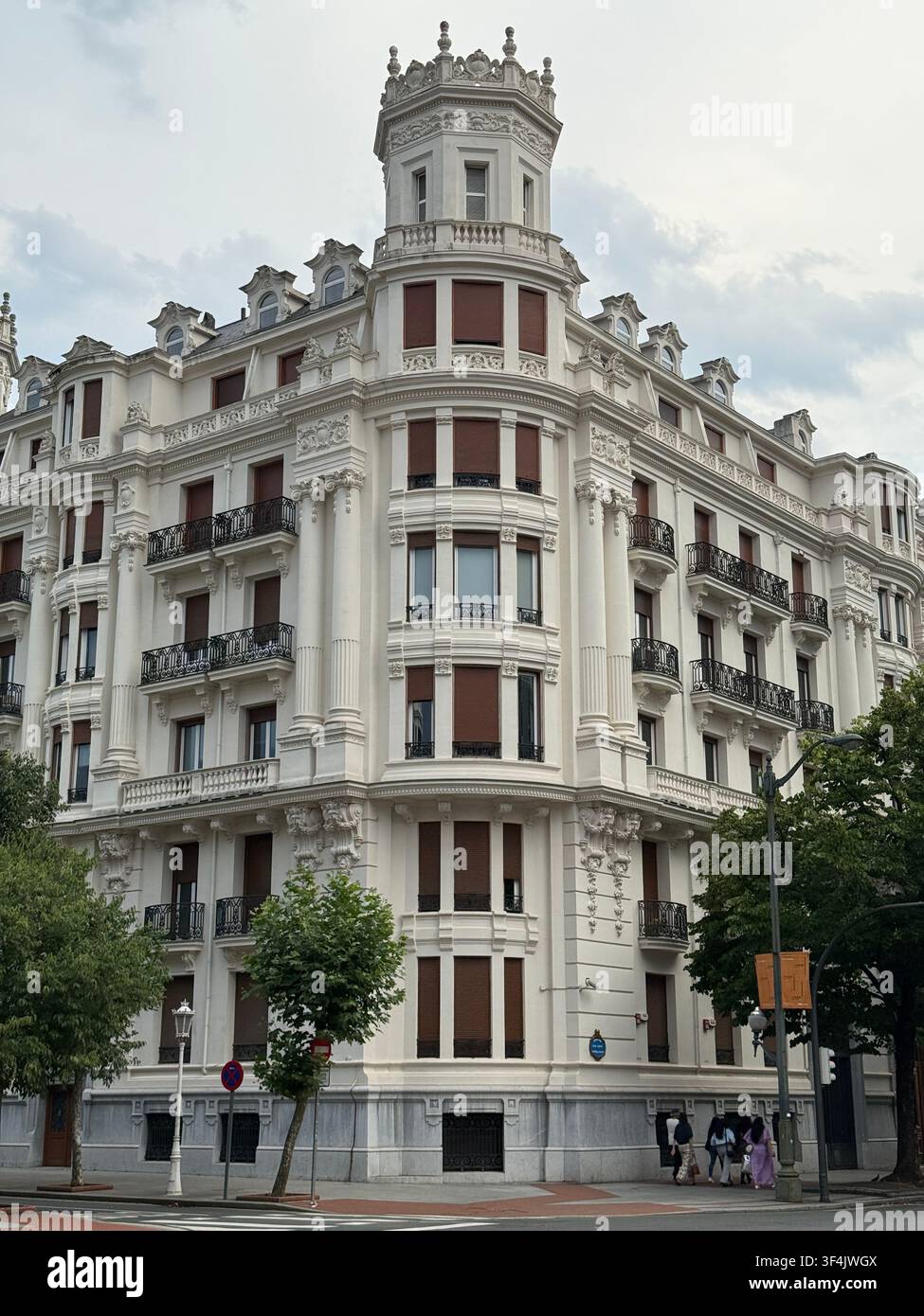Verziertes Wohngebäude aus dem frühen zwanzigsten Jahrhundert an einer Straßenecke im Zentrum von Bilbao, Spanien. - Smartphone-aufgenommenes Stockfoto
