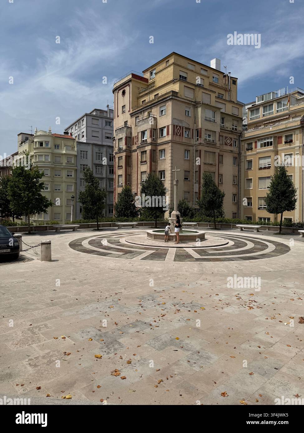 Rund gemusterter Platz mit einem kleinen Brunnen und Wohngebäuden im Zentrum von Santander, Spanien. - Smartphone-aufgenommenes Stockfoto