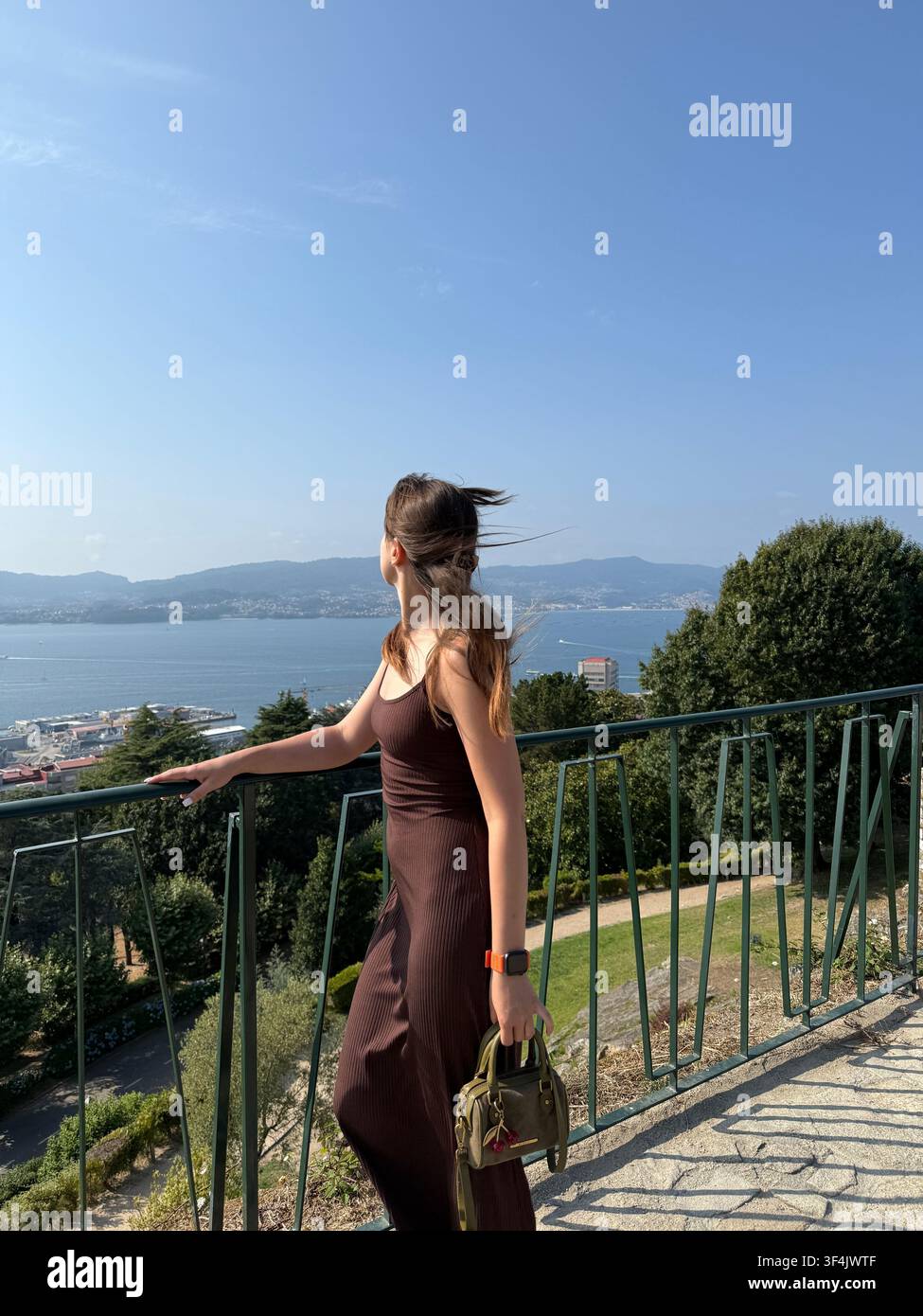 Junge Frau blickt über die Bucht von Vigo von einem Aussichtspunkt an der Festung Castro, Galizien, Spanien - Smartphone-aufgenommenes Stockfoto